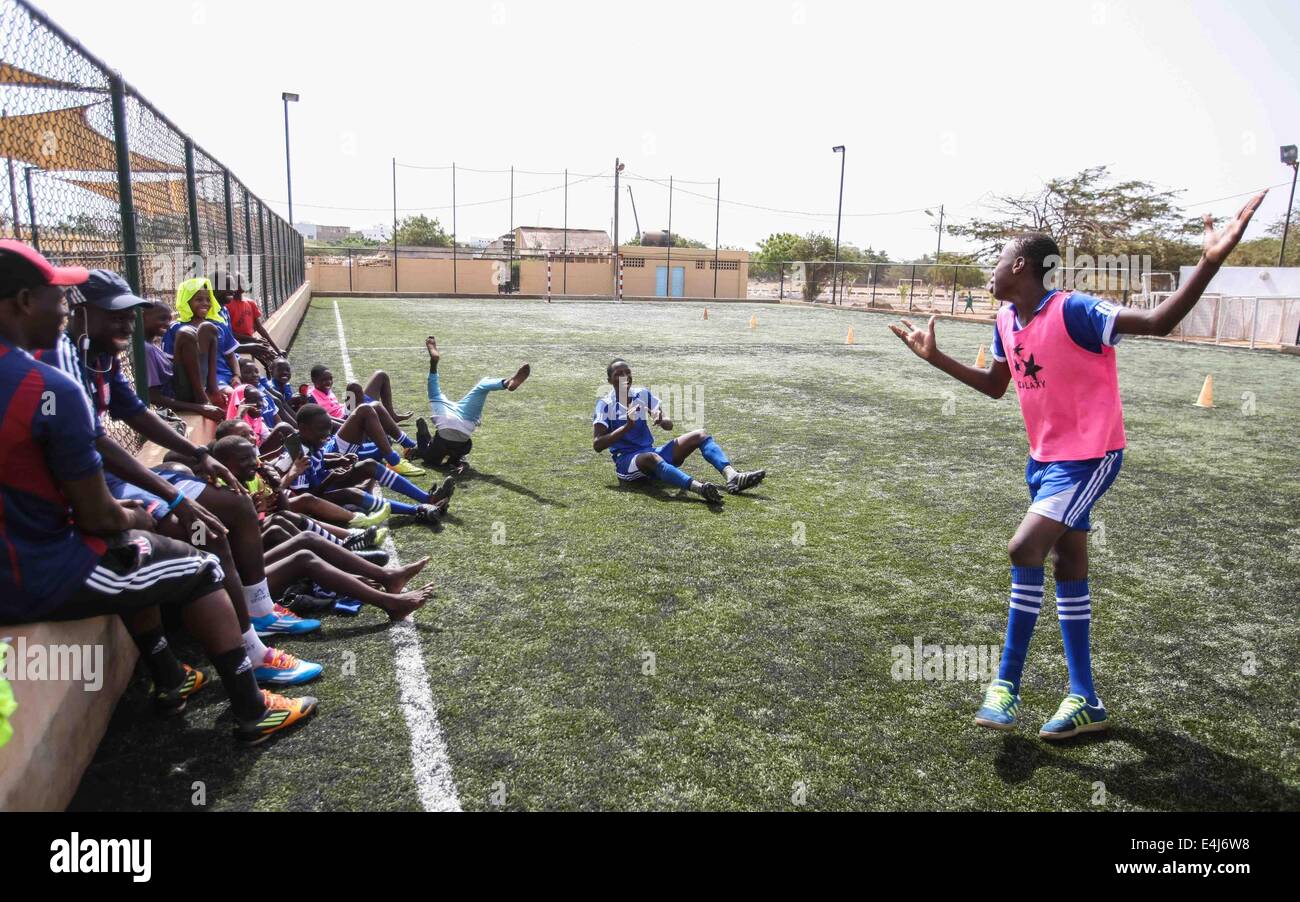 Dakar, Senegal. 12. Juli 2014. Ein Fußballspieler der Sport 4 Charity Tänze als Strafe für ein Spiel zu verlieren nach einer Trainingseinheit in Dakar, der Hauptstadt des Senegal, 12. Juli 2014. Sport 4 Charity wurde vom senegalesischen wählte Spieler Salif Diao armen Jugendlichen aus Afrika eine Chance haben, einen Zugang zu Bildung und Sport helfen gegründet. Die jungen Spieler verfügen über Mittel und Einrichtungen und Möglichkeiten, europäische oder amerikanische Footall Mannschaften zu dienen, nachdem sie ihre Ausbildungen abgeschlossen haben. © Li Jing/Xinhua/Alamy Live-Nachrichten Stockfoto