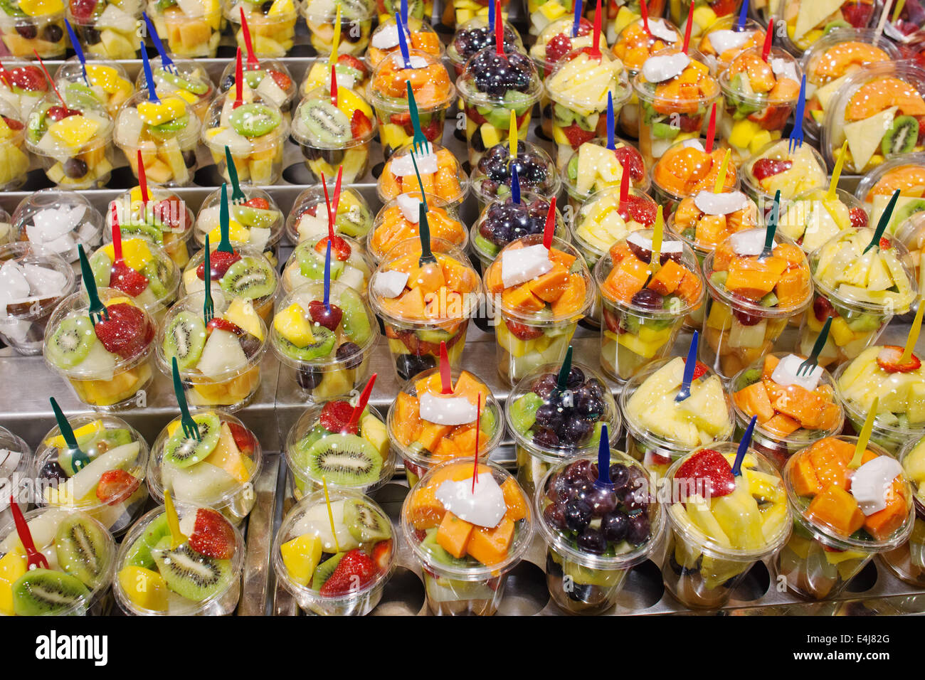 Frisch, geschnitten, geschälte Mischung der Früchte der verschiedenen Arten in den Behältern mit Gabeln auf einem Marktstand, gesunde Ernährung nahrhafte Straße f Stockfoto