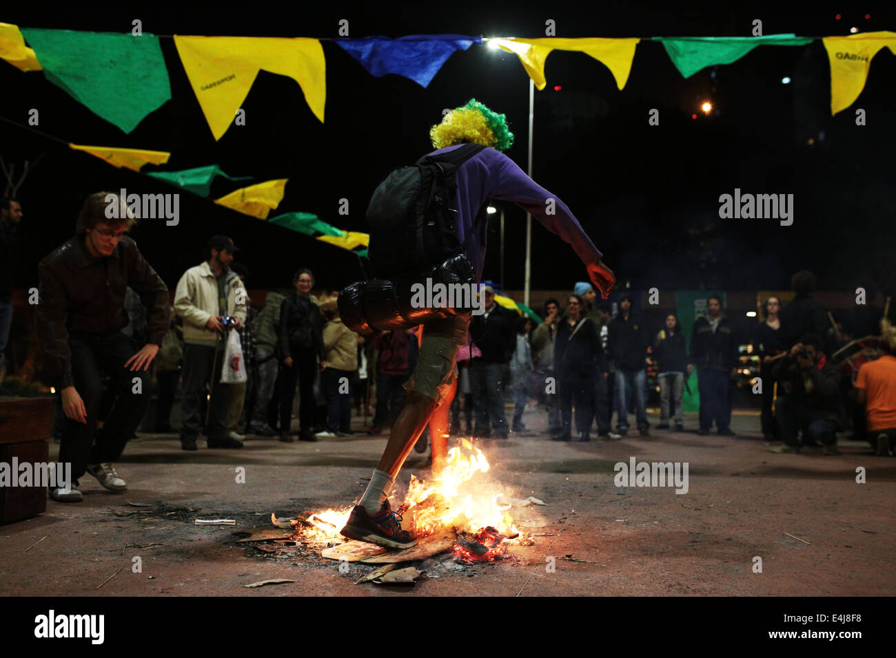 Sao Paulo, Brasilien. 12. Juli 2014. Ein Demonstrant durchläuft ein Lagerfeuer bei einem Protest gegen die Inhaftierung von Aktivisten, die in einer früheren Demonstration gegen die FIFA WM 2014 in Roosevelt festgenommen wurden quadratische. Bildnachweis: Tiago Mazza Chiaravalloti/Pacific Press/Alamy Live-Nachrichten Stockfoto