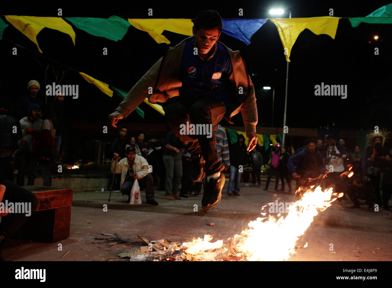 Sao Paulo, Brasilien. 12. Juli 2014. Ein Demonstrant springt über einem Lagerfeuer während einer Protestaktion gegen das Gefängnis von Aktivisten, die in einer früheren Demonstration gegen die Fifa WM 2014 in Roosevelt Platz festgenommen wurden. Bildnachweis: Tiago Mazza Chiaravalloti/Pacific Press/Alamy Live-Nachrichten Stockfoto