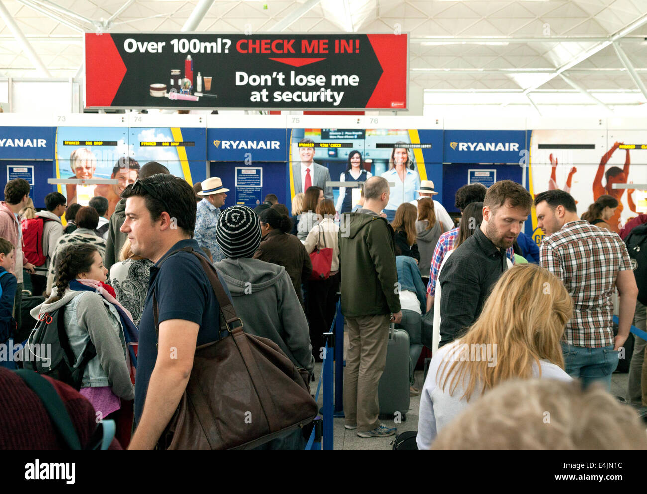 Passagier-Warteschlange bei Ryanair Check-in-Schalter, Flughafen Stansted, London UK Stockfoto