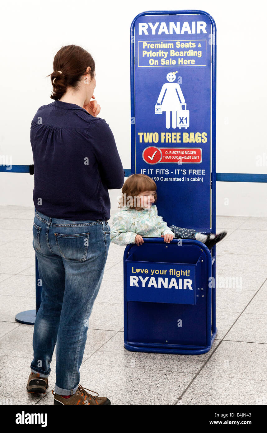 Ein Kind spielt beim Ryanair Gepäck einchecken, Flughafen Stansted, London UK Stockfoto