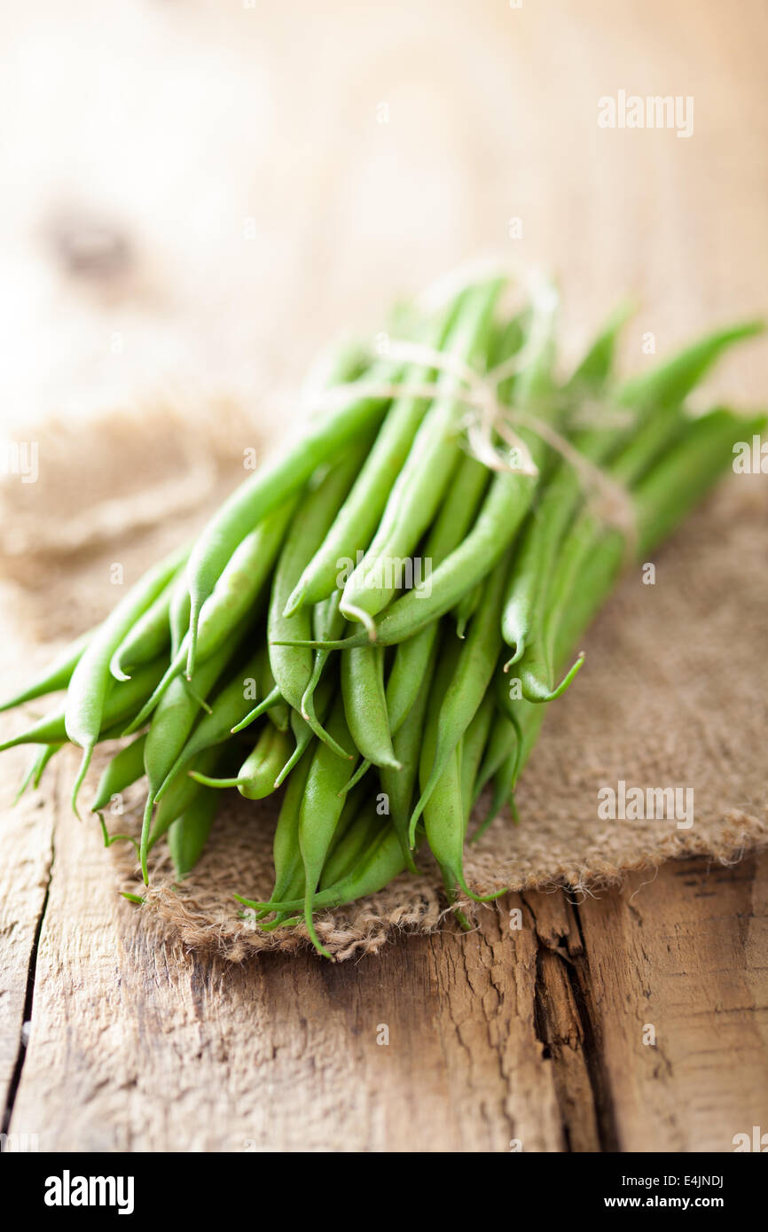 frische grüne Bohnen über hölzerne Hintergrund Stockfoto