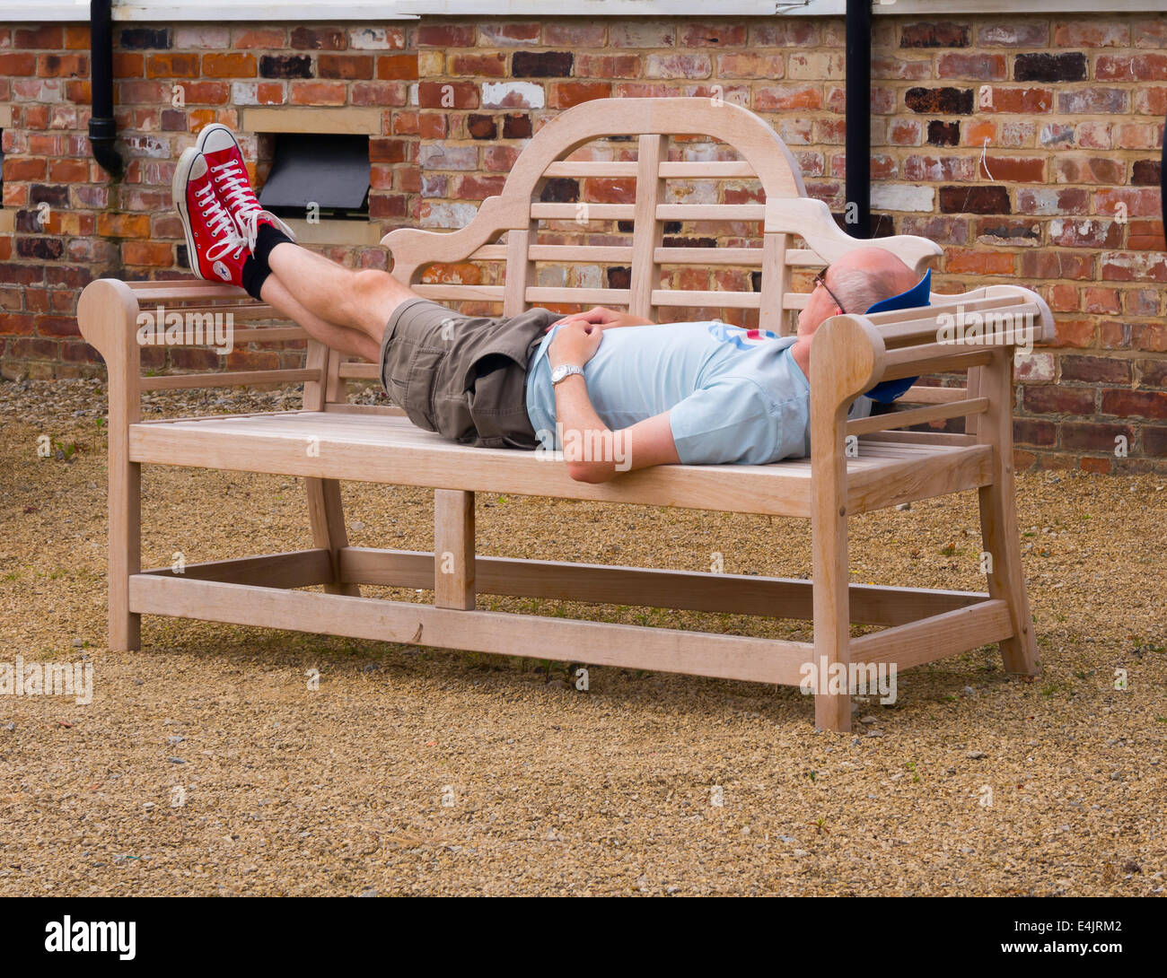 Man ruht auf einer Holzbank in einem Gartencenter Stockfoto