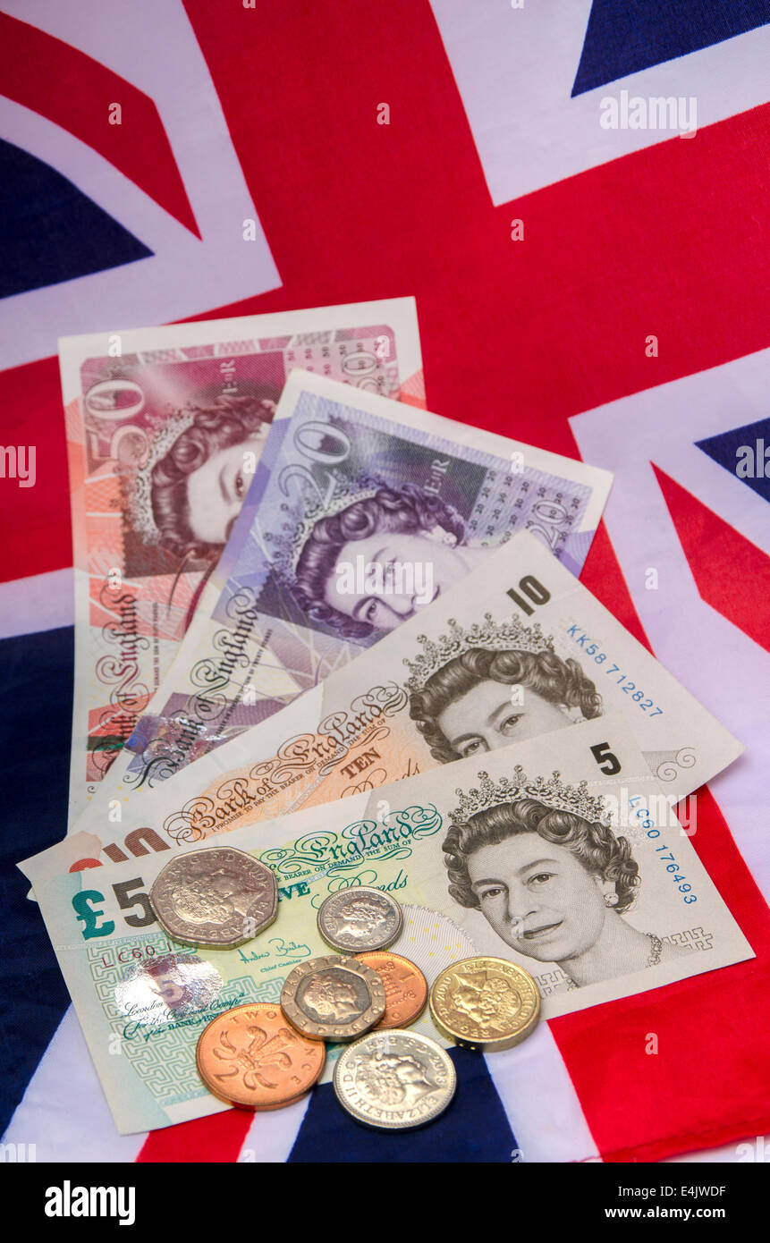 Britische Pfund-Noten und Münzen auf eine Union Jack-Flagge Stockfoto