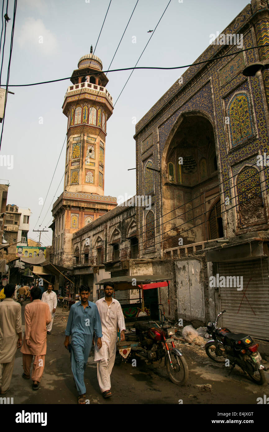 Menschen auf der Straße mit Wazir Khan Moschee dahinter in Lahore Stockfoto