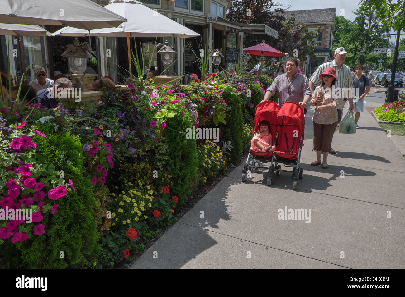 Touristen gehen von einem der vielen bunten Blüten zeigt die in der historischen alten Stadt von Niagara-on-the-Lake, Ontario, Kanada zu finden. Stockfoto