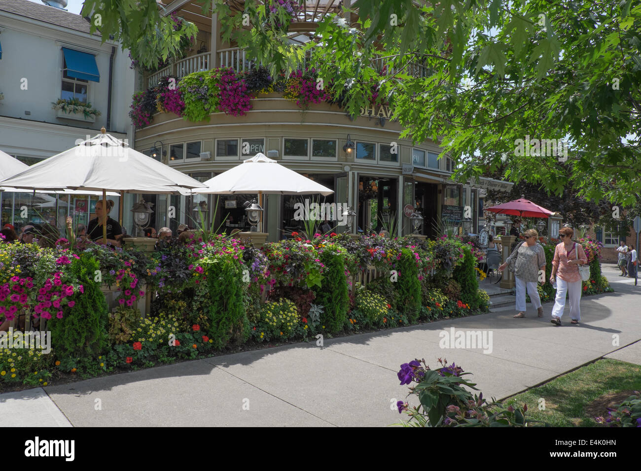 Touristen gehen von einem der vielen bunten Blüten zeigt die in der historischen alten Stadt von Niagara-on-the-Lake, Ontario, Kanada zu finden. Stockfoto