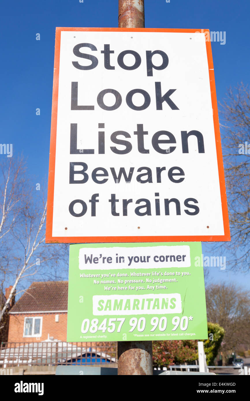 Stop sehen hören. Vorsicht vor Züge Zeichen mit den Samaritern Kontaktdaten unterhalb an einem Bahnübergang, Nottinghamshire, England, Großbritannien Stockfoto