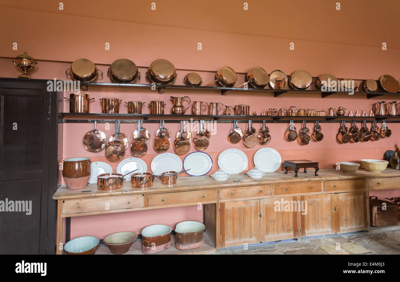 Glänzende Küchengeräte aus Kupfer, Töpfe, Pfannen, Töpfe, Töpfe, Tassen, weißes Abendessen und Servierplatten, die in der Felbrigg Hall, Norfolk, Großbritannien, ausgestellt sind Stockfoto