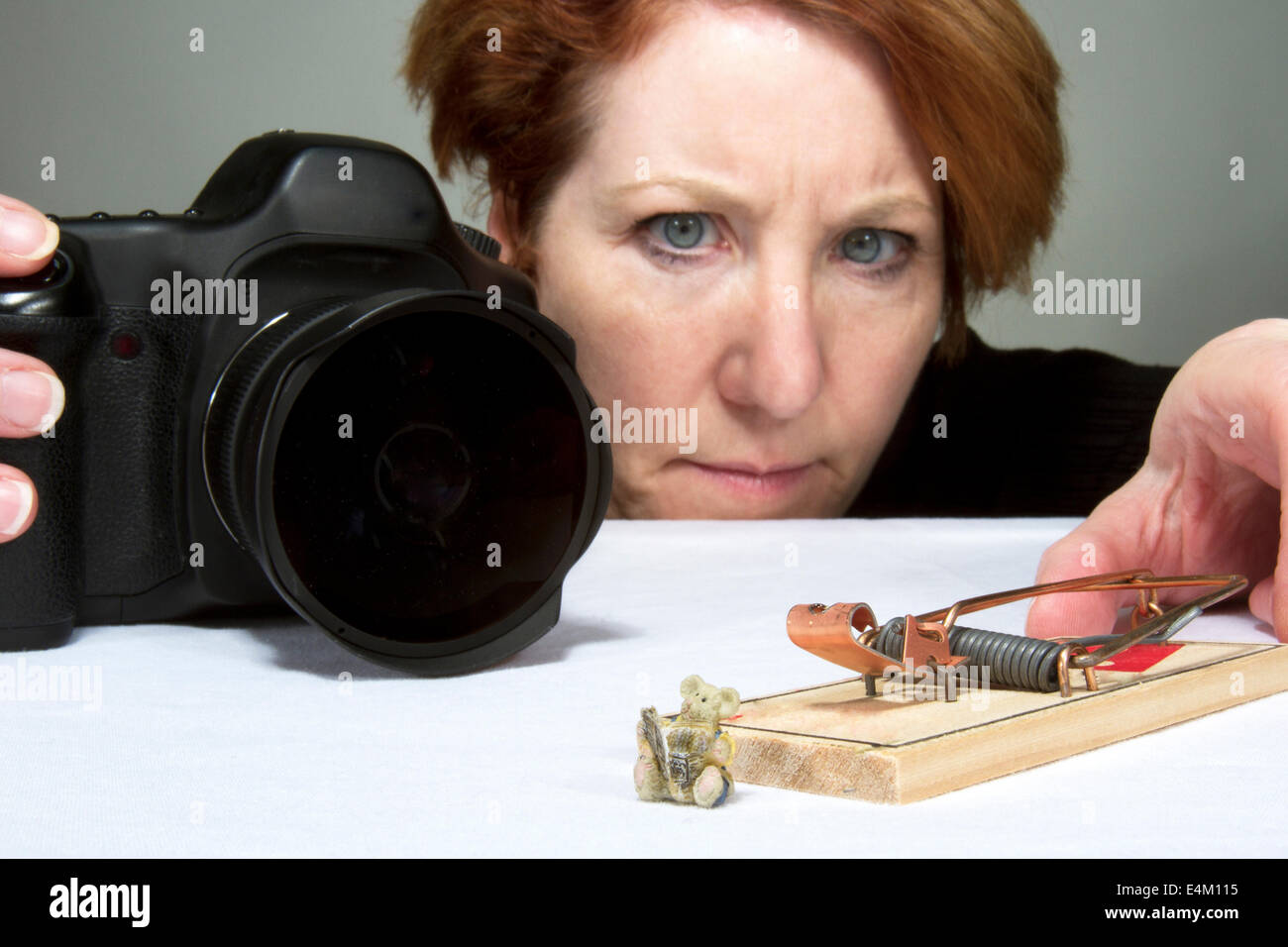 Fotografin, die eine Szene mit einer Maus und einer Mausefalle einrichten Stockfoto