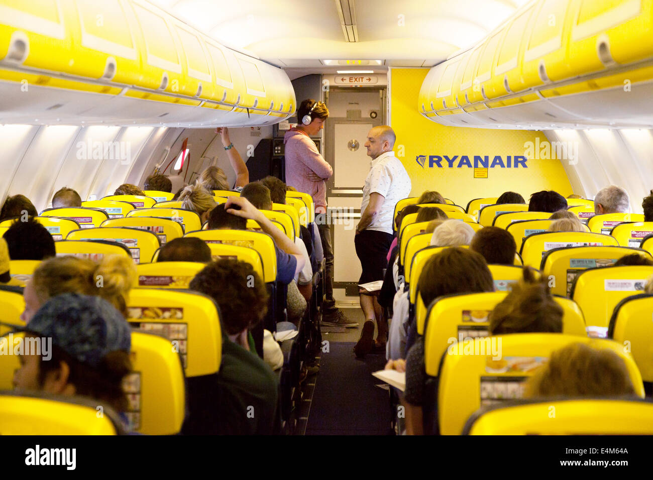 Passagiere in einer Warteschlange für die Toilette während des Fluges, Ryanair-Flugzeug-Kabinenausstattung Stockfoto