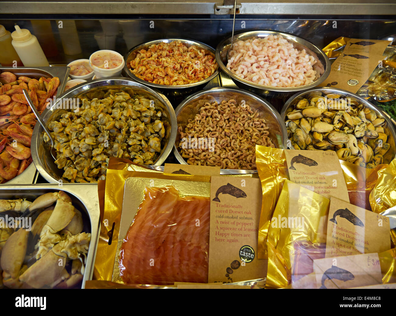 Auswahl an Meeresfrüchten.  Frische lokale Garnelen, grauen Garnelen, Krebse und Muscheln mit Päckchen Räucherlachs im Ladengeschäft Dorset Meeresfrüchte Stockfoto