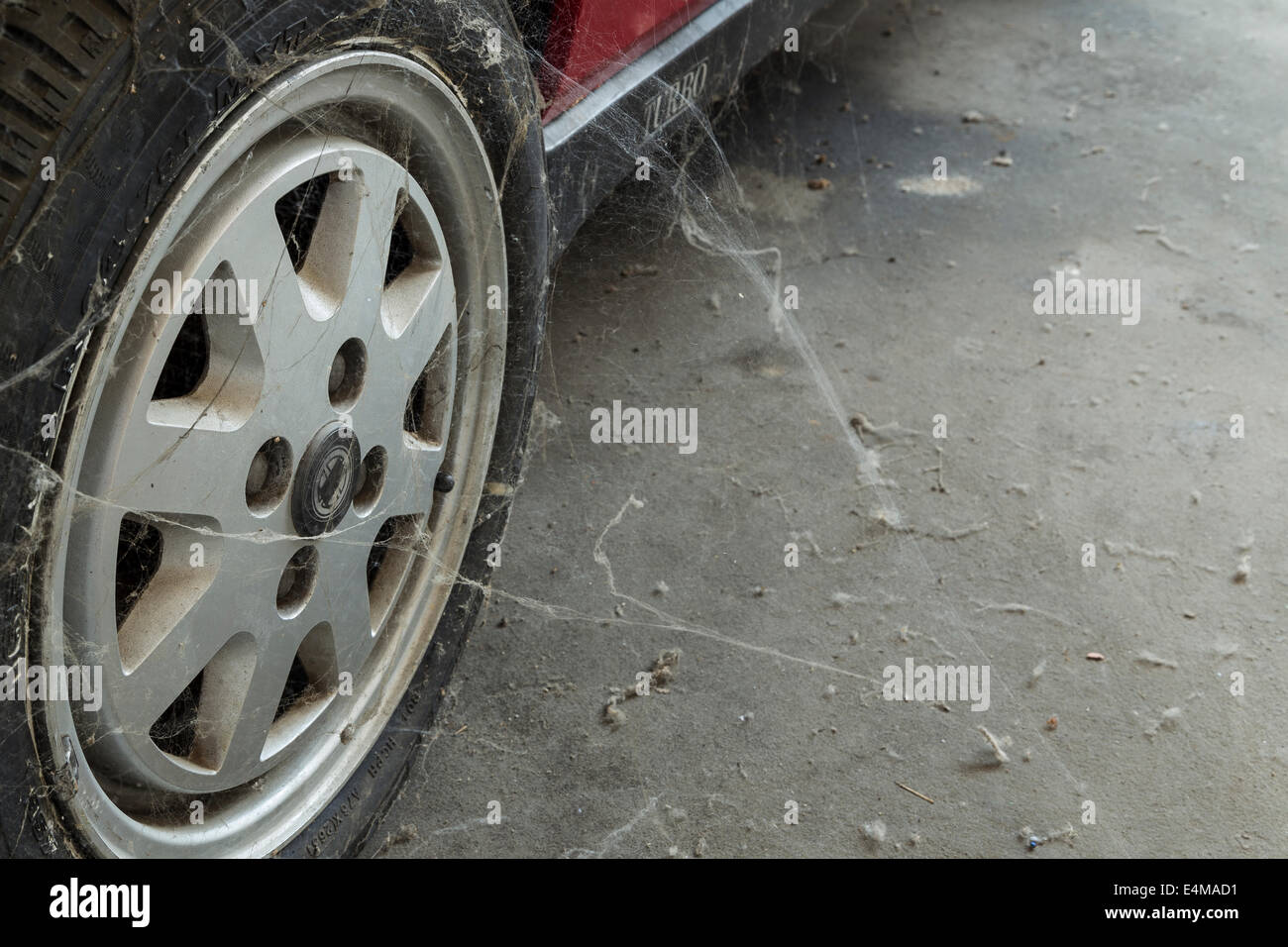 Ein 80er-Pkw-Reifen unter Spinnweben und Staub Stockfoto