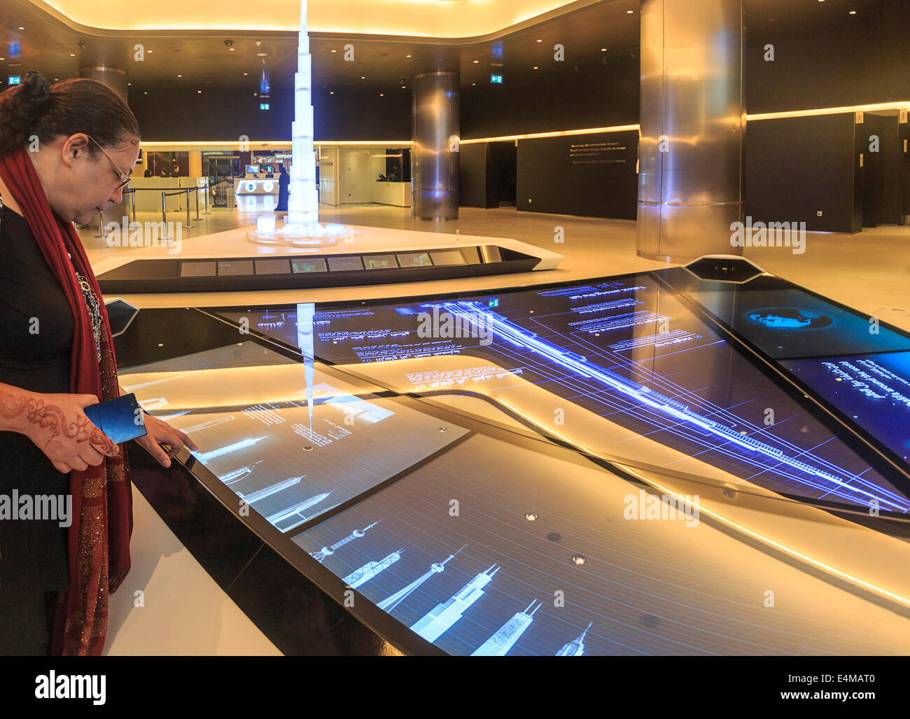 Frau Ansichten Informationstafel an der Basis des Eingangs zum Burj Khalifa, das höchste der Welt bauen Stockfoto