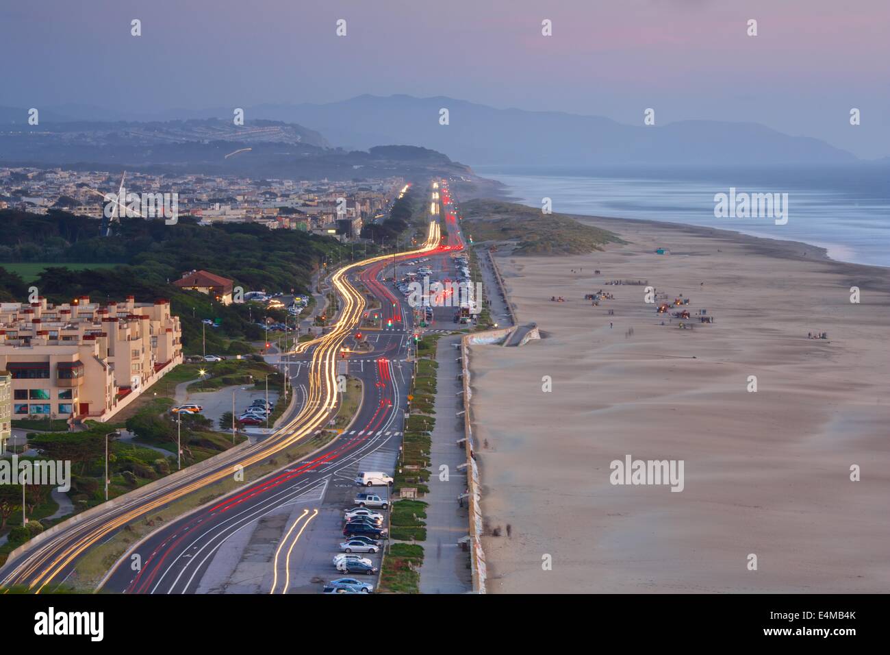 Schöne Aussicht auf den Great Highway entlang Ocean Beach nach Sonnenuntergang mit Autos Streifen entlang der Küste. Stockfoto