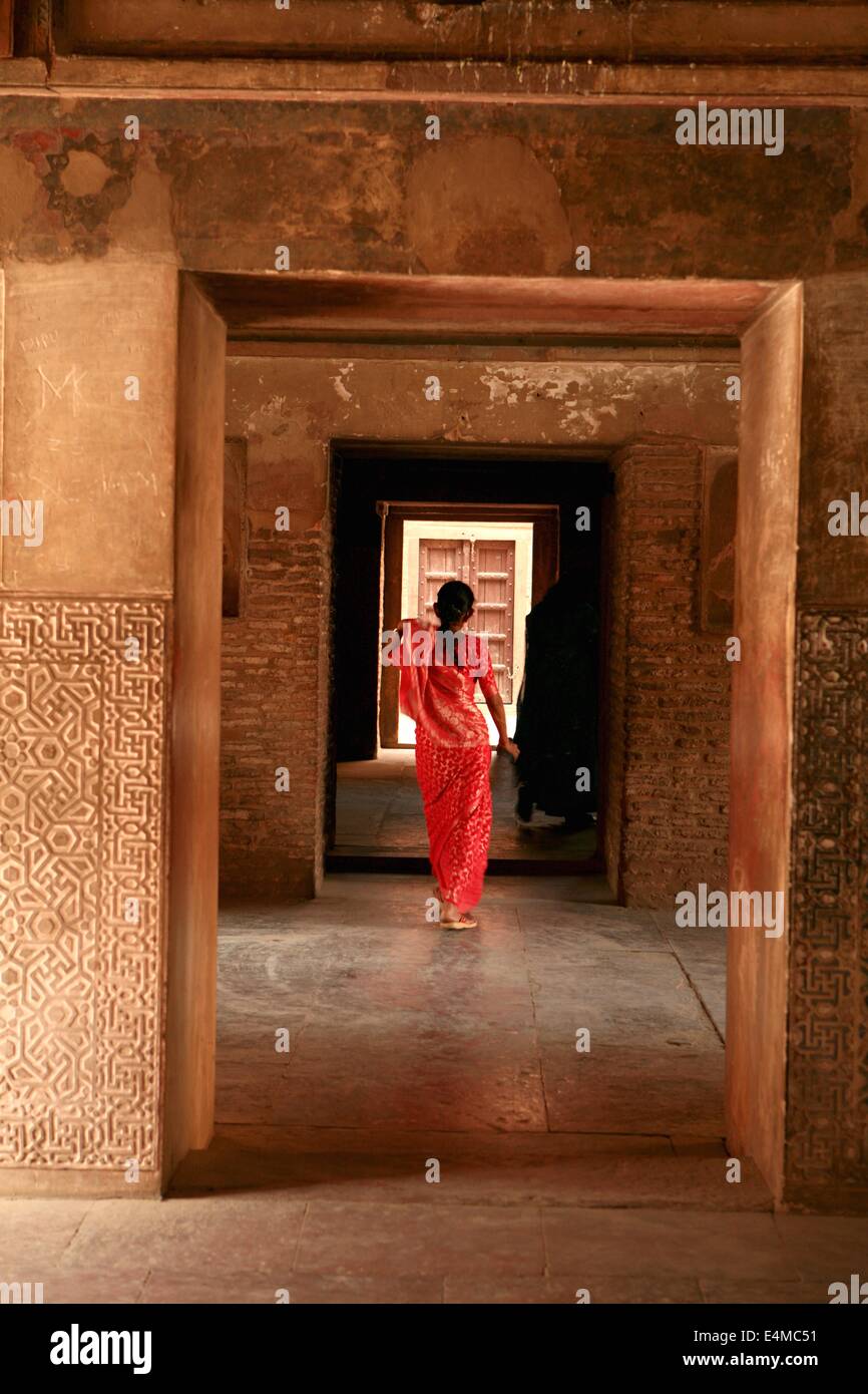 Eine Frau trägt einen roten Sari geht durch einen Korridor in das Amber Fort in Jaipur Rajasthan Indien Stockfoto