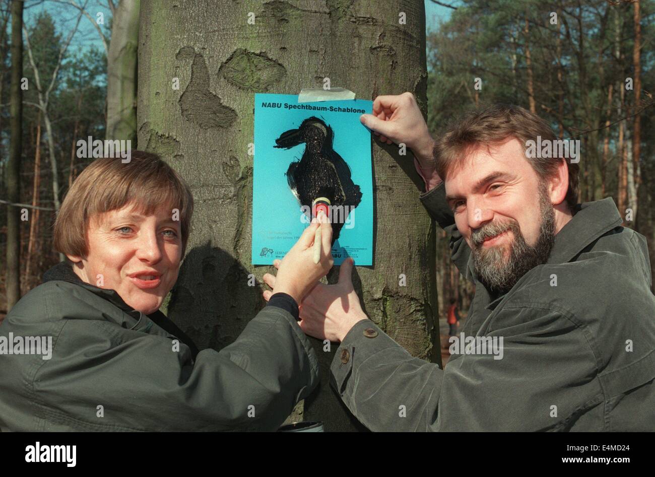 Datei - zeigt eine Archiv Bild vom deutschen Minister für Umwelt Angela Merkel markieren Bäume bewohnt durch Spechte mit Präsident der Natur und Biodiversität Conservation Union (NABU) Jochen Flasbarth in Berlin-Grunewals, Deutschland. Merkel wird 60 am 17. Juli 2014. Foto: Nestor Bachmann/dpa Stockfoto