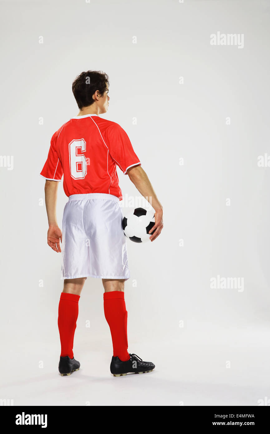 Football-Spieler in einem weißen und roten uniform steht vor weißem Hintergrund Stockfoto