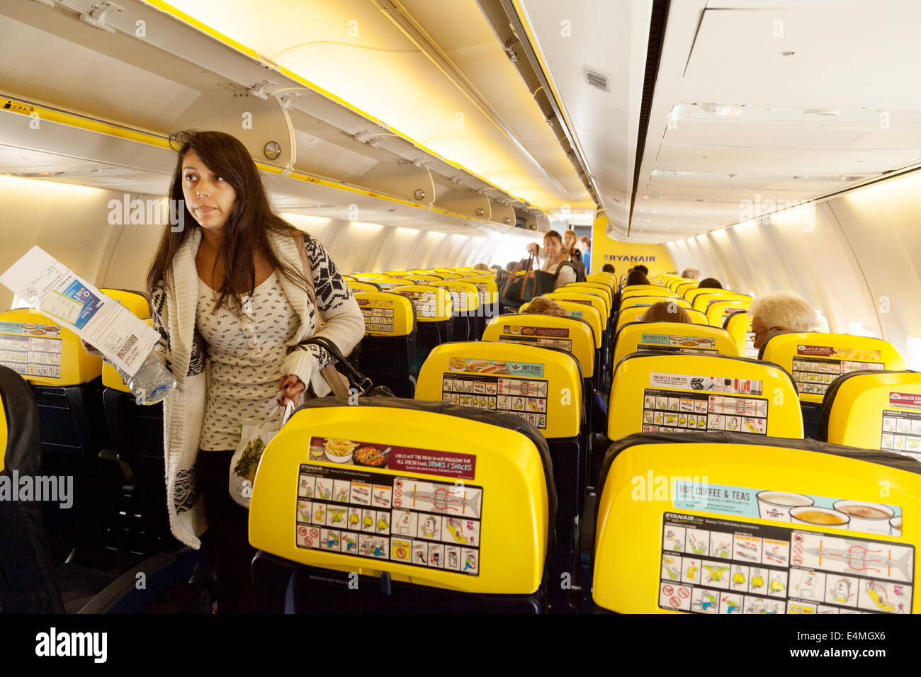 Passagiere finden ihre Sitze, Ryanair-Flugzeug-Kabinenausstattung Stockfoto