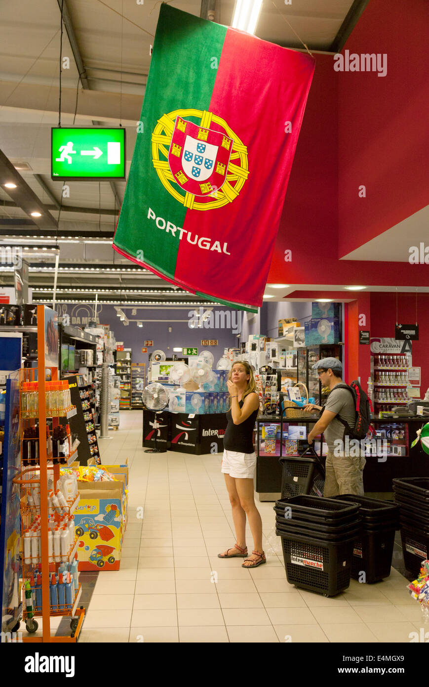 Menschen beim Einkaufen in das Innere eines Supermarktes mit der portugiesischen Flagge, Lagoa, Algarve, Portugal Stockfoto