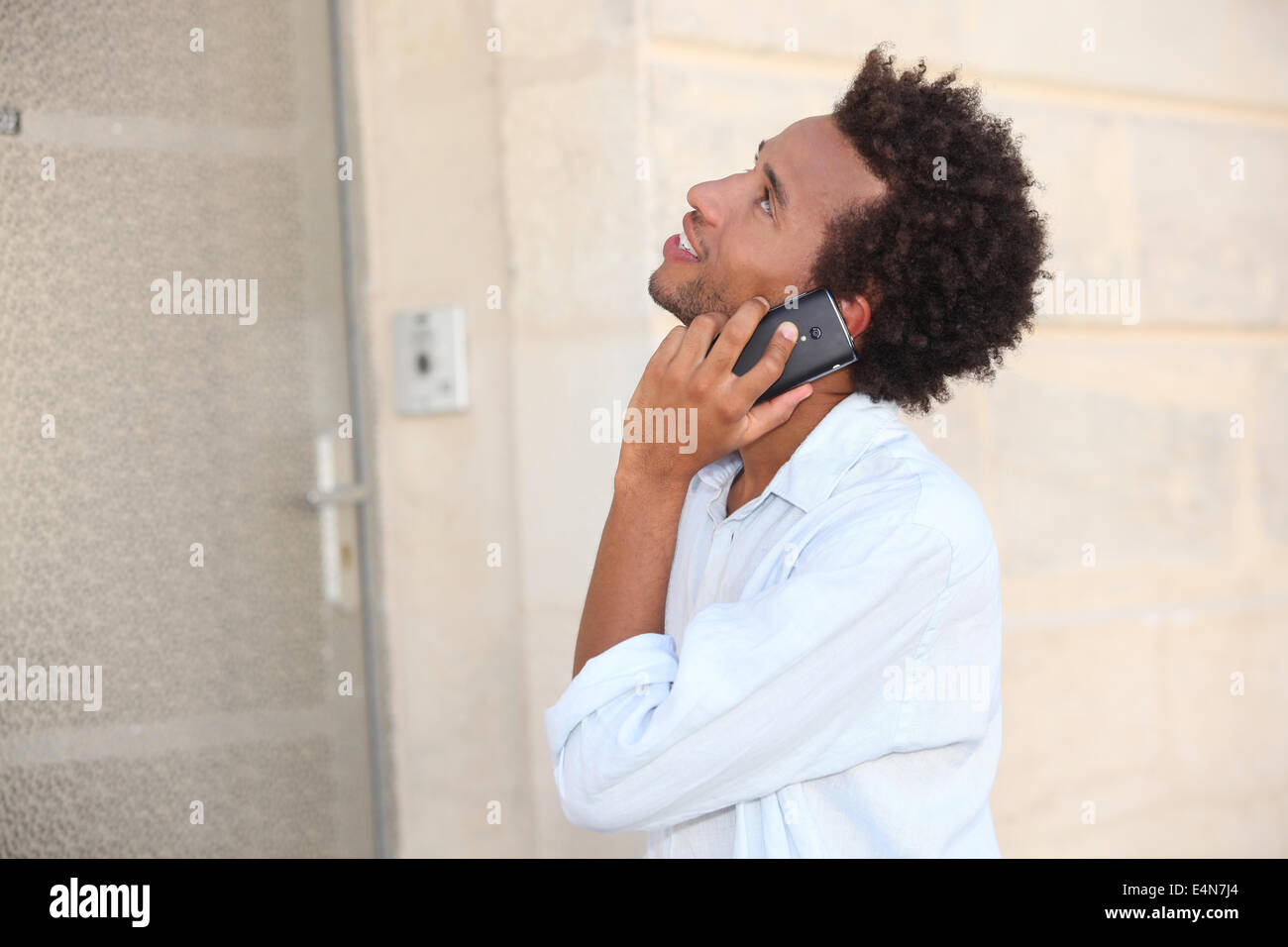 ein Mann am Telefon vor einer verschlossenen Tür Stockfoto