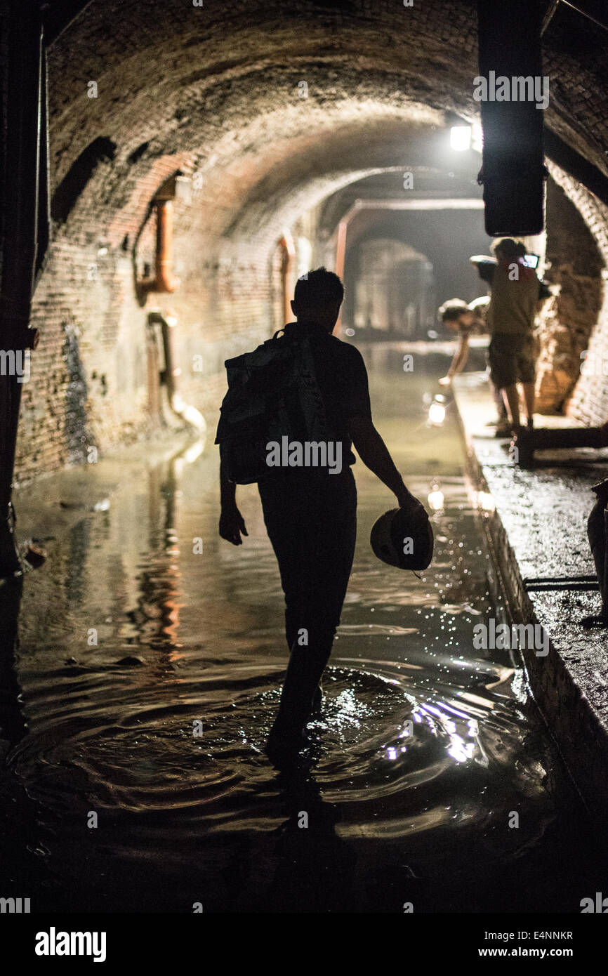 Silhouette des Menschen waten durch Wasser in unterirdischen tunnel Stockfoto