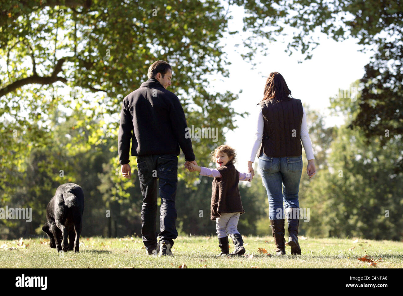 Familie, die ihren Hund spazieren gehen Stockfoto