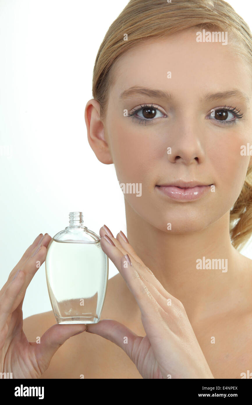 Junge Frau hält eine Flasche Parfüm Stockfoto