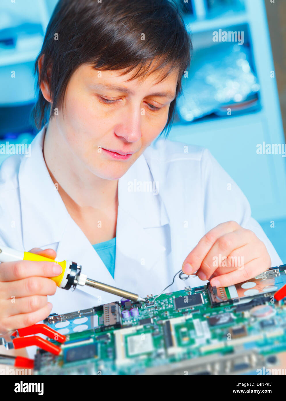 Frau-Reparaturen-Computer-board Stockfoto