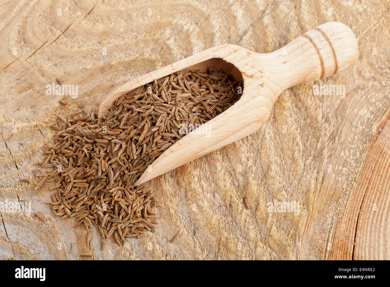 Getrockneten Kümmel oder Kreuzkümmel Samen in hölzerne Schaufel auf rustikalen Holz Hintergrund Stockfoto
