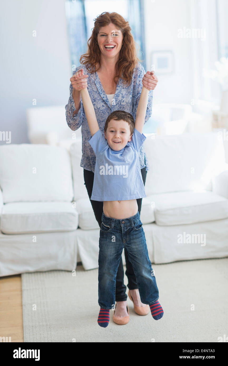 Mutter und Sohn (6-7) spielen im Wohnzimmer Stockfoto