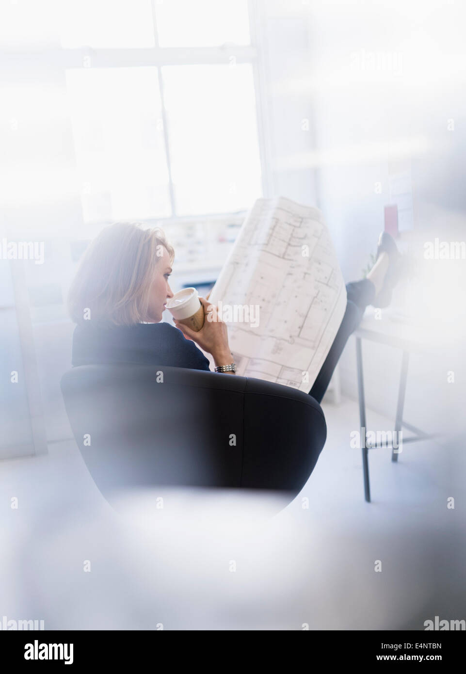 Business-Frau betrachten Blaupause im Büro Stockfoto