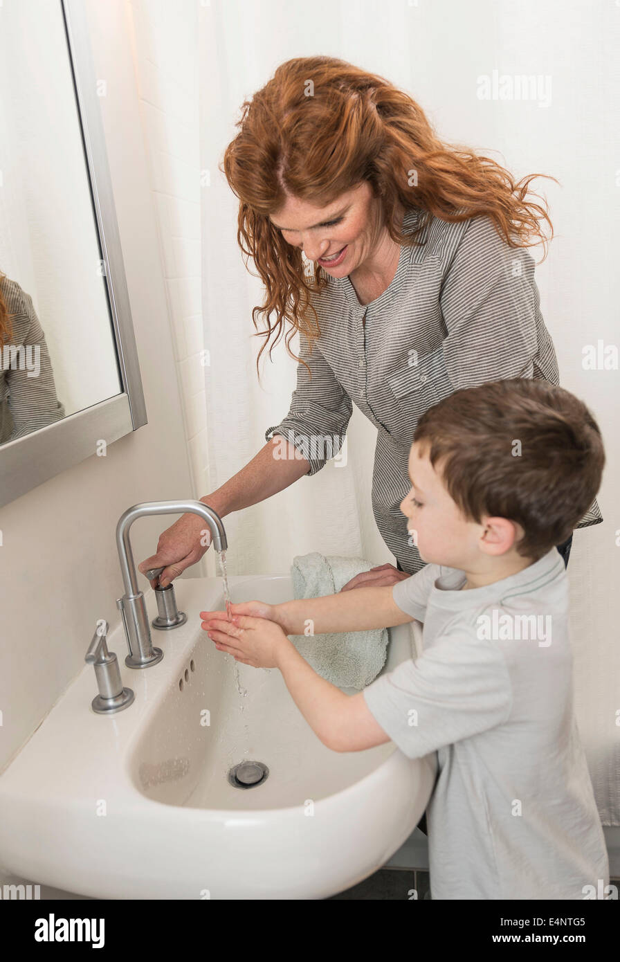 Sohn (6-7) und Mutter, die Hände zu waschen Stockfoto