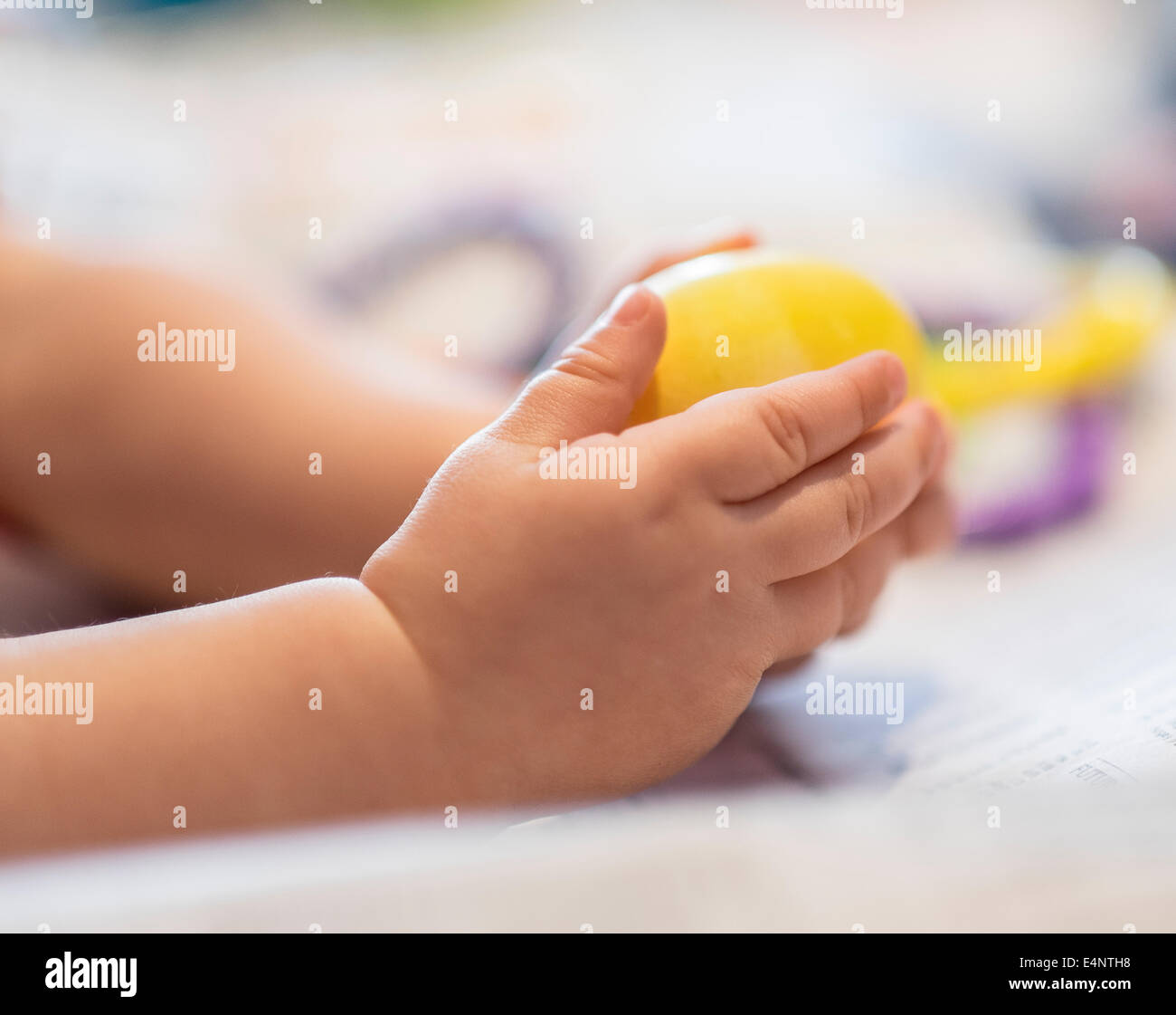 Händen des Mädchens (6-11 Monate) hält Spielzeug Stockfoto