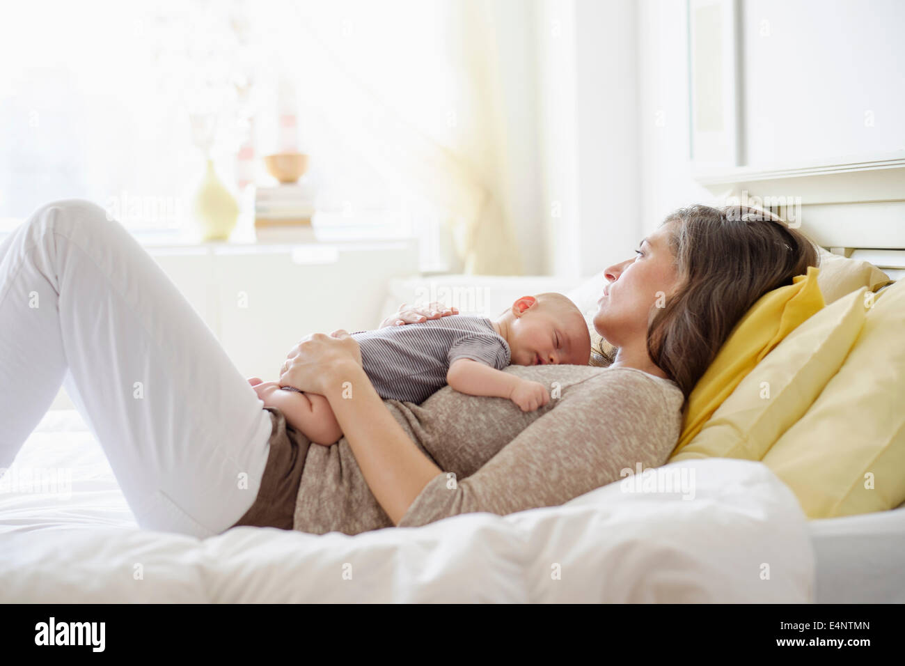 Mutter mit Baby Boy (2-5 Monate) im Bett liegen Stockfoto