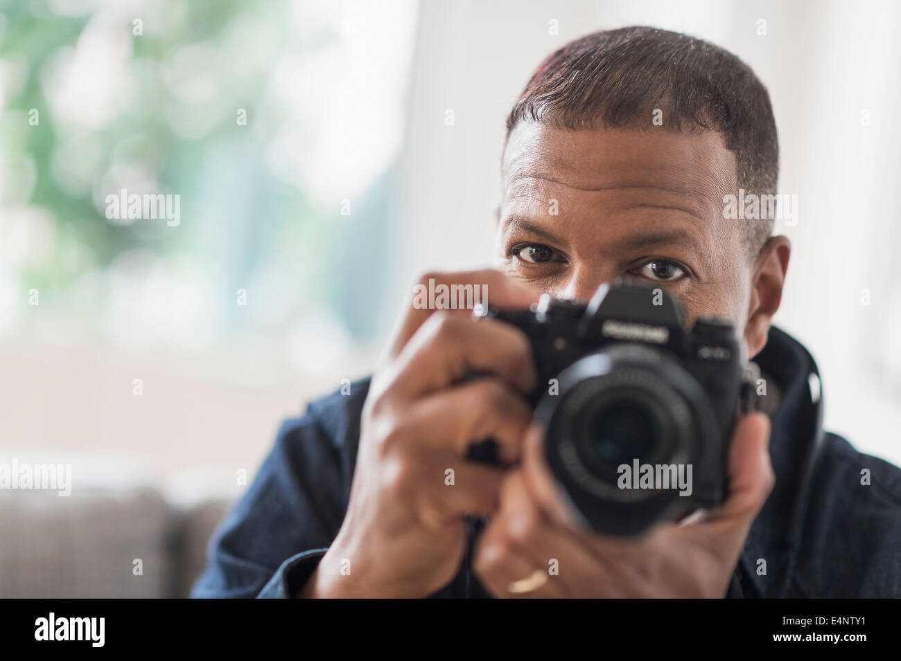 Porträt des Mannes hält Digitalkamera Stockfoto