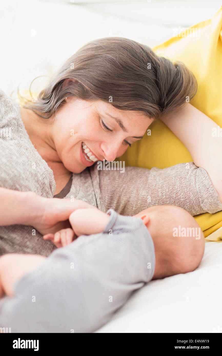 Mutter mit Baby Boy (2-5 Monate) auf Bett liegend Stockfoto