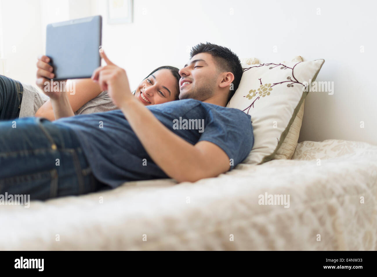 Junges Paar mit digital-Tablette im Bett Stockfoto