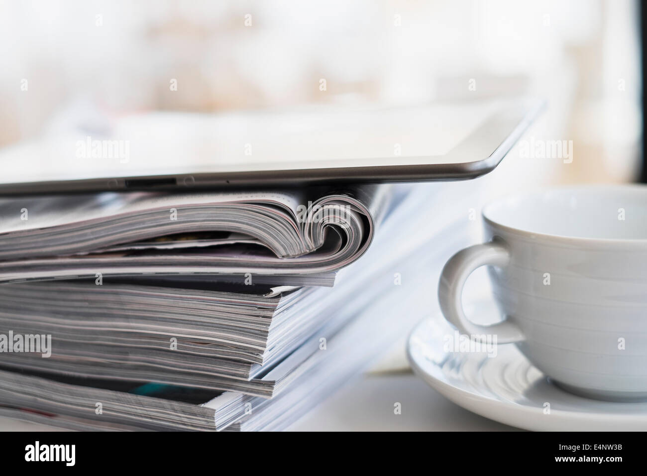 Nahaufnahme der Kaffeetasse und digital-Tablette auf Magazin Stapel Stockfoto