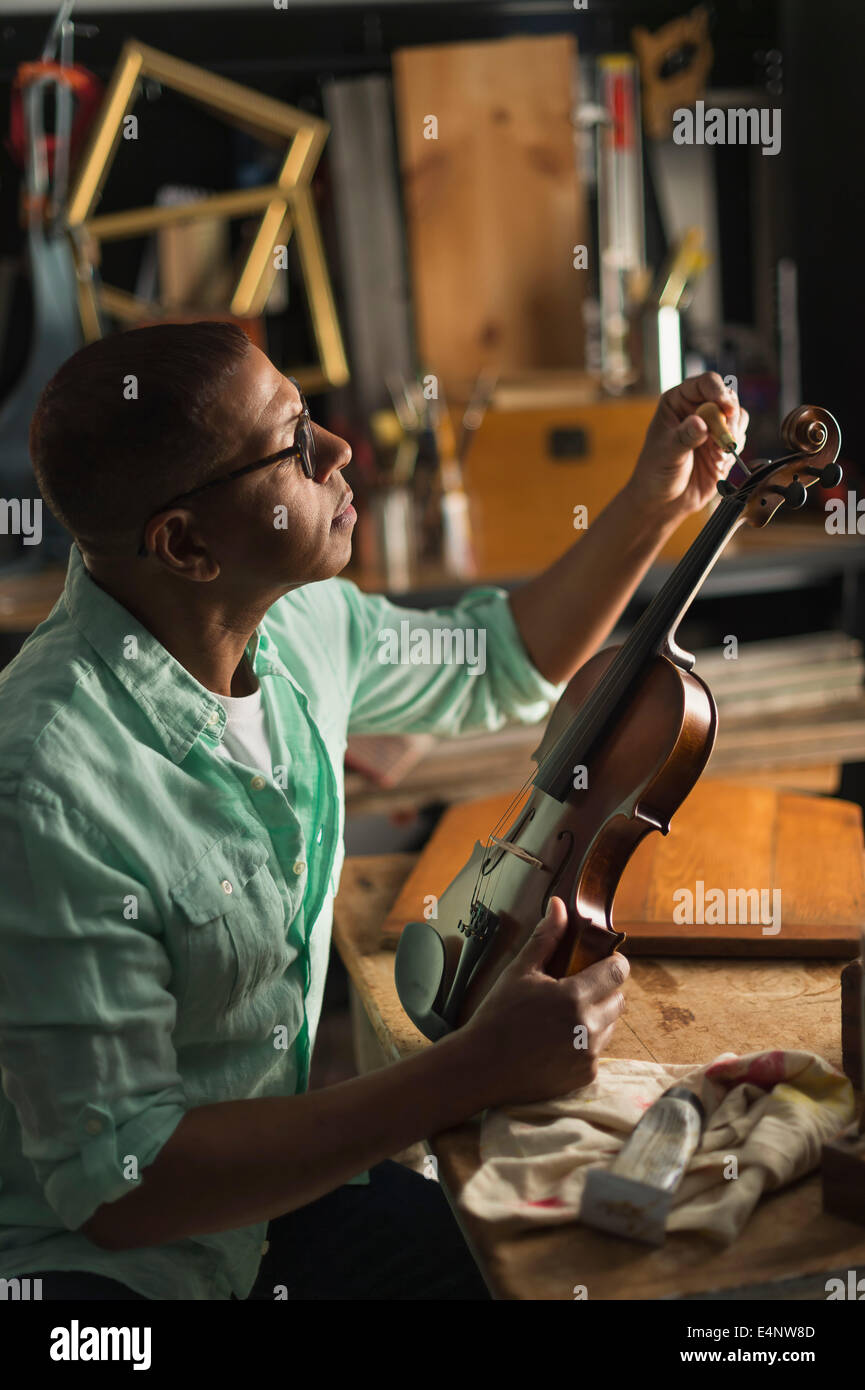 Reifer Mann Violine in seiner Werkstatt reparieren Stockfoto