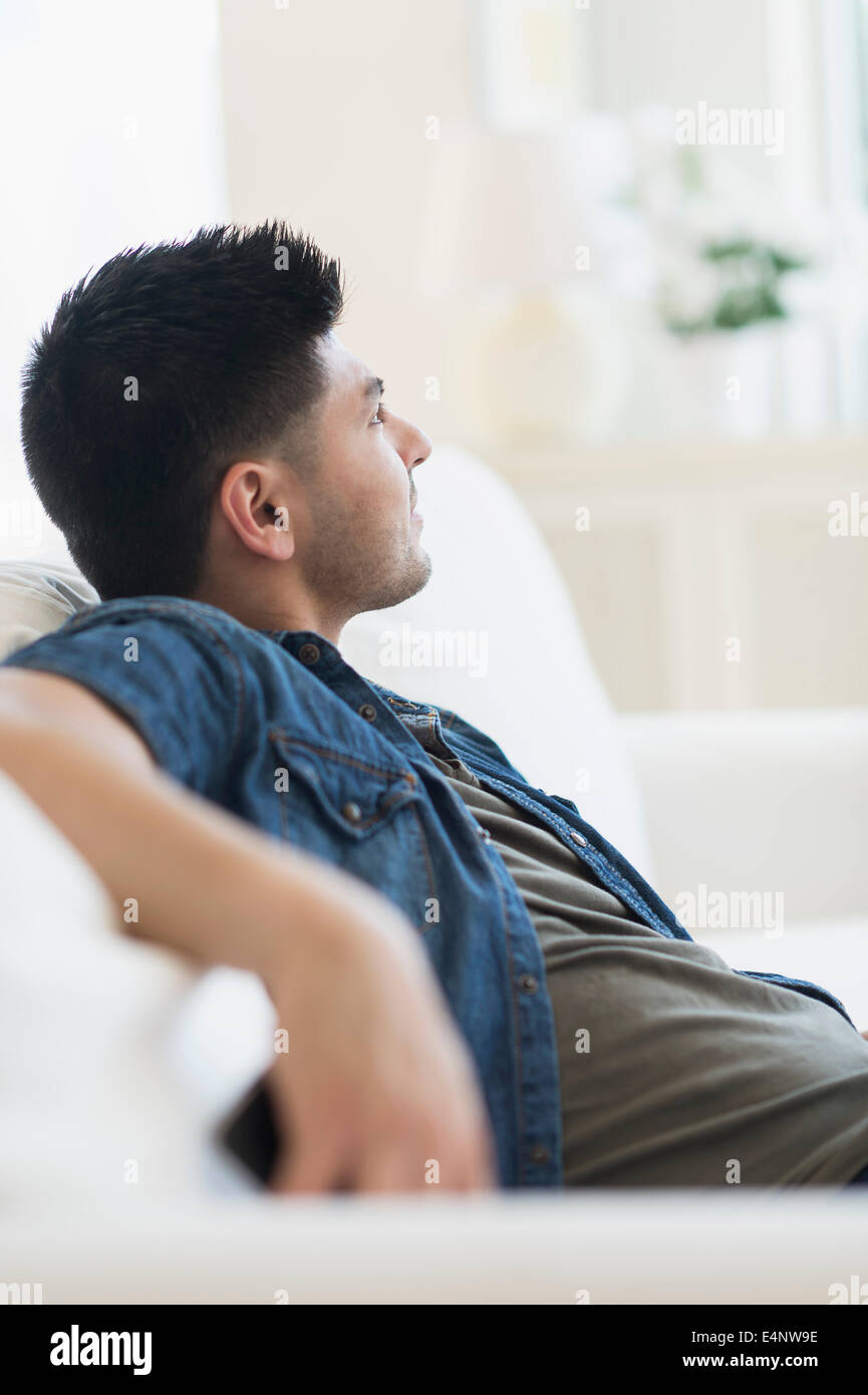 Junger Mann auf sofa Stockfoto