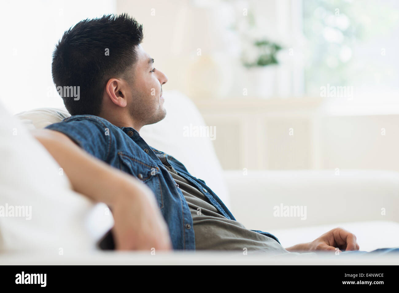 Junger Mann auf sofa Stockfoto