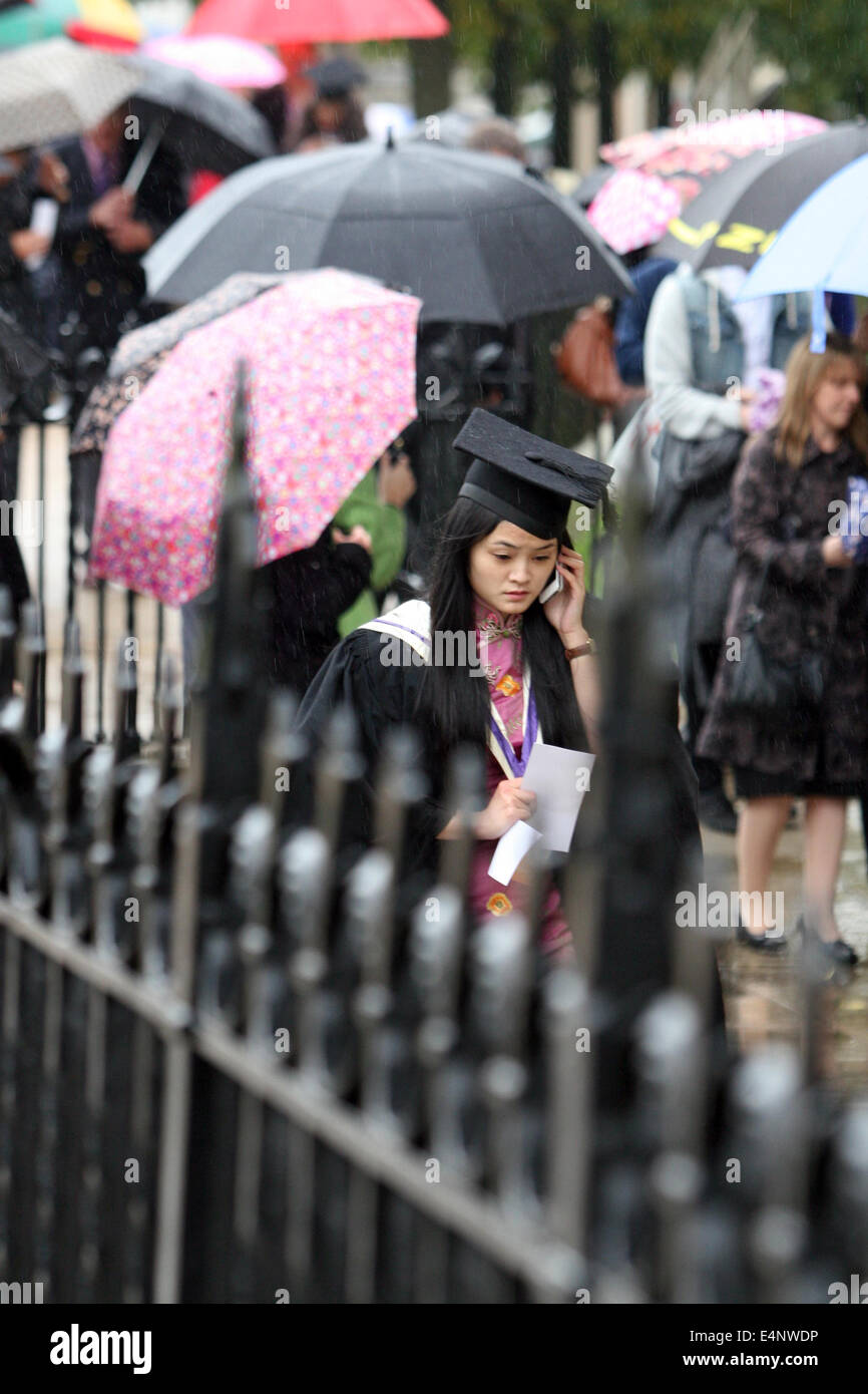 Eine nervöse aussehende Diplomand macht einen Anruf vor dem Besuch ihrer Abschlussfeier. Stockfoto