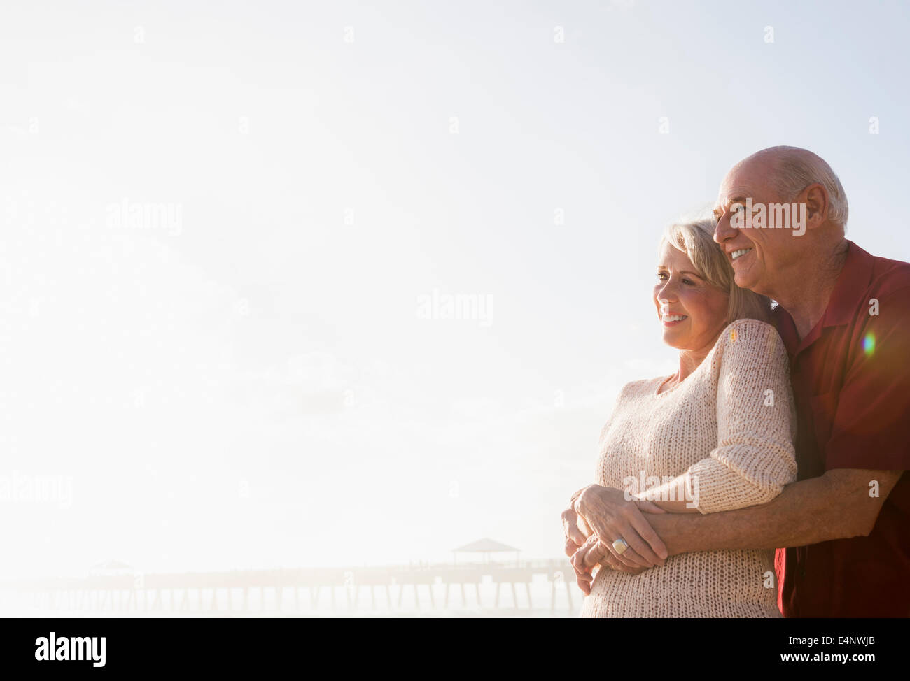 Älteres paar umarmt am Strand Stockfoto