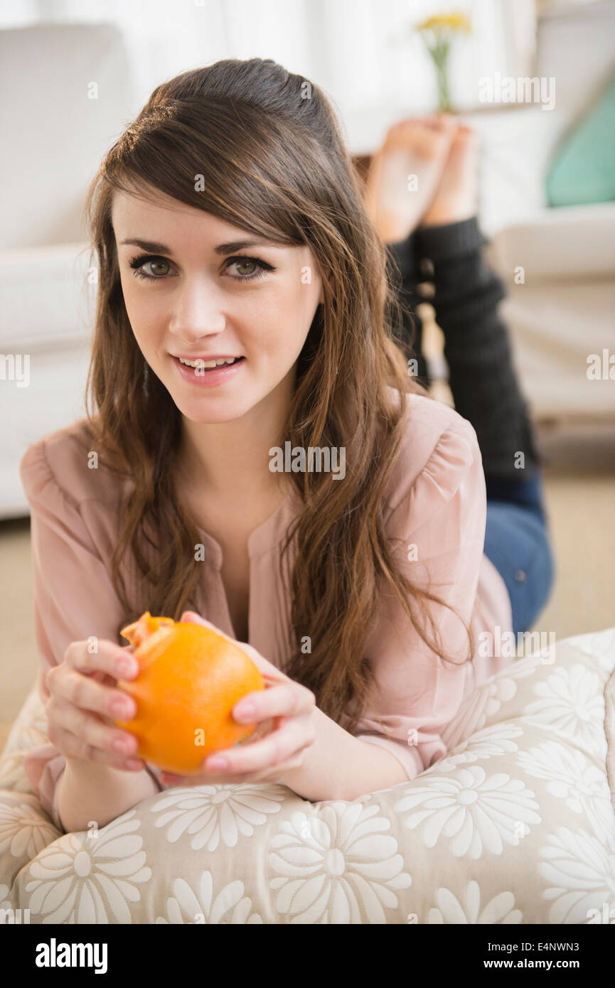 Junge Frau Essen orange Stockfoto