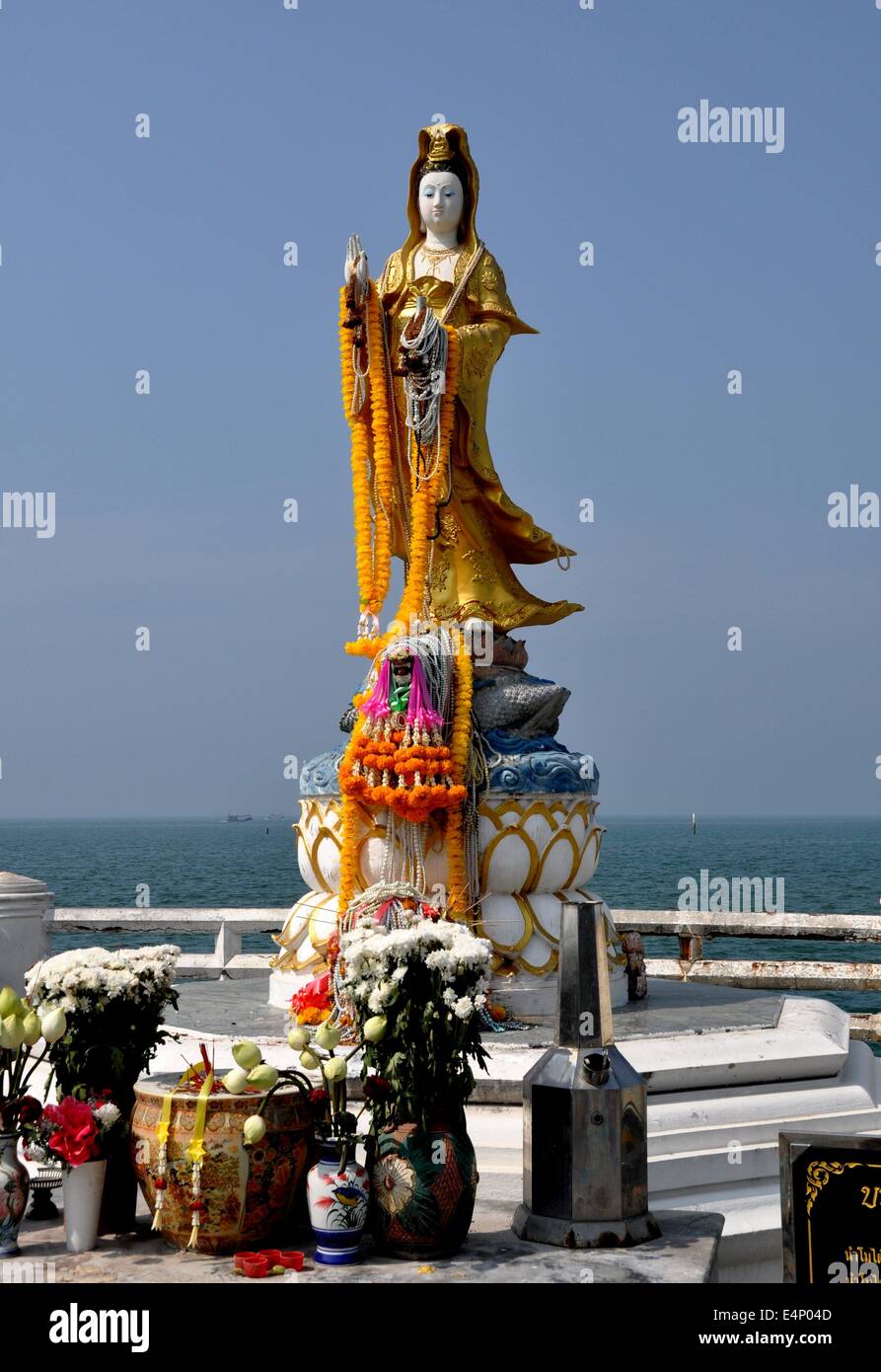 Bang Saen, Thailand: Eine große Guan Yin Buddha geschmückt mit Angeboten steht am Meer an der Strandpromenade Stockfoto