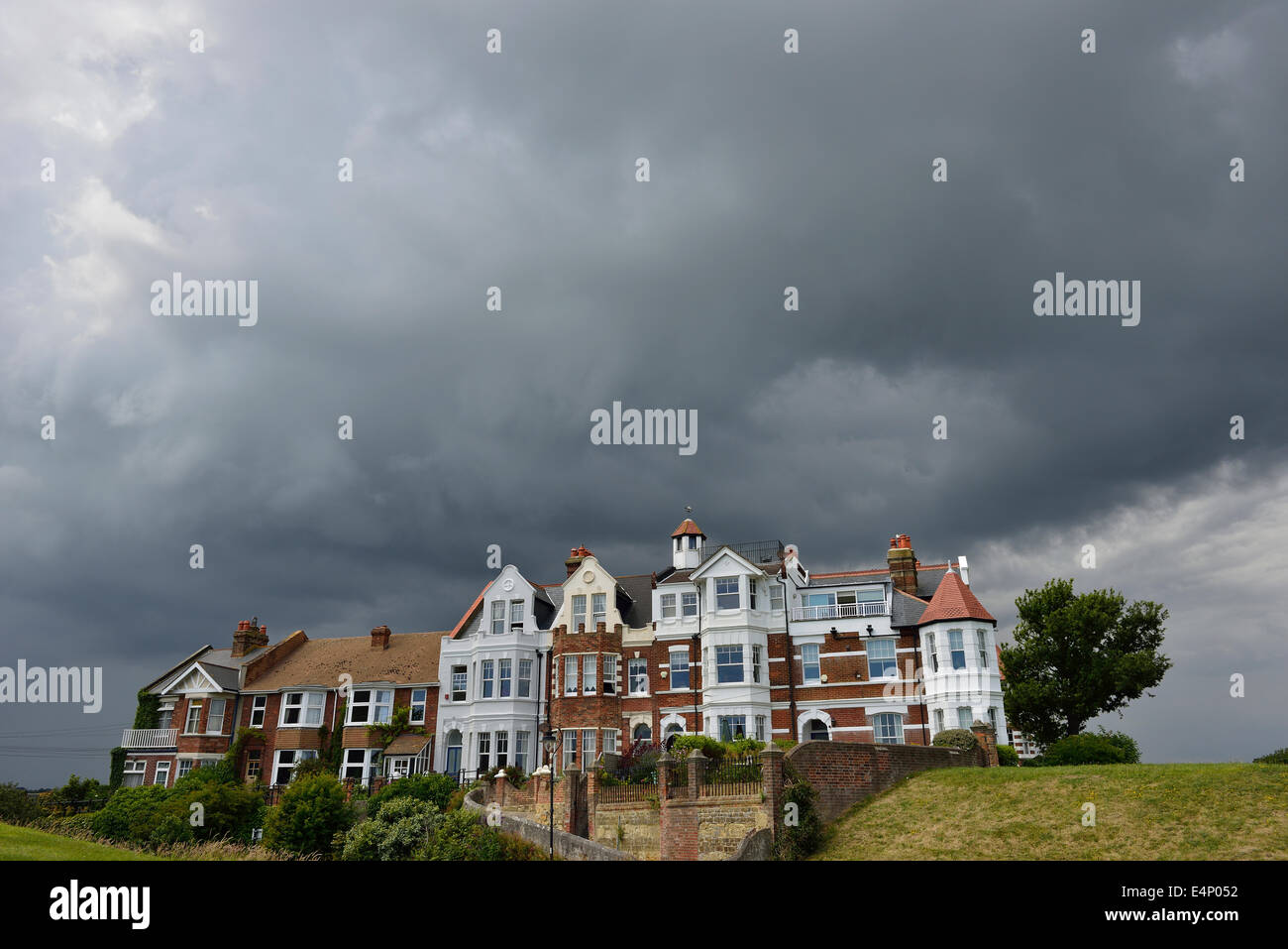 Gewitterwolken über eine Reihe von Wohnhäusern Stockfoto