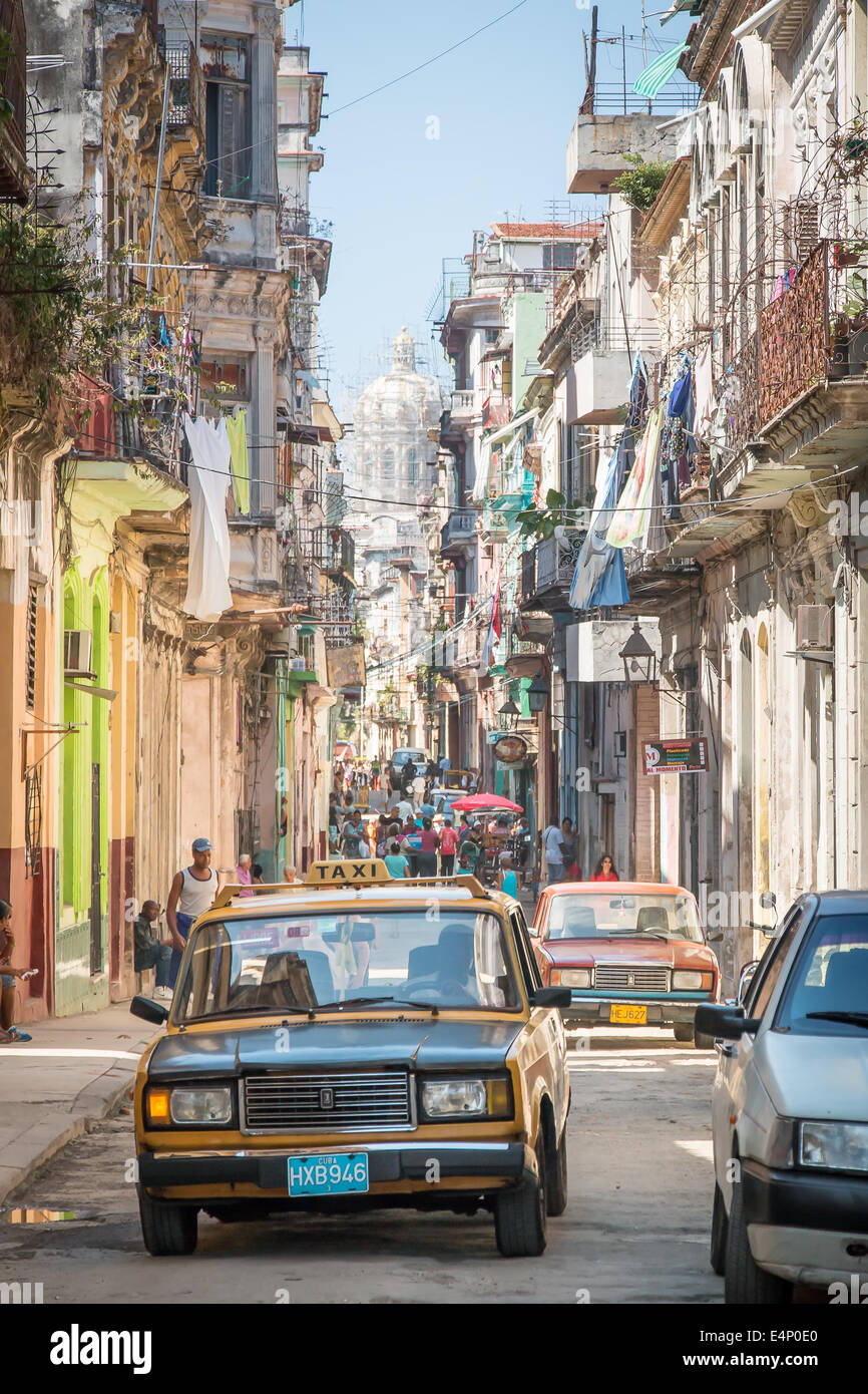 Alten Lada Taxi fahren auf belebten Straße von Havanna Vieja mit National-Kapitol-Gebäudes im Hintergrund, Havanna, Kuba Stockfoto