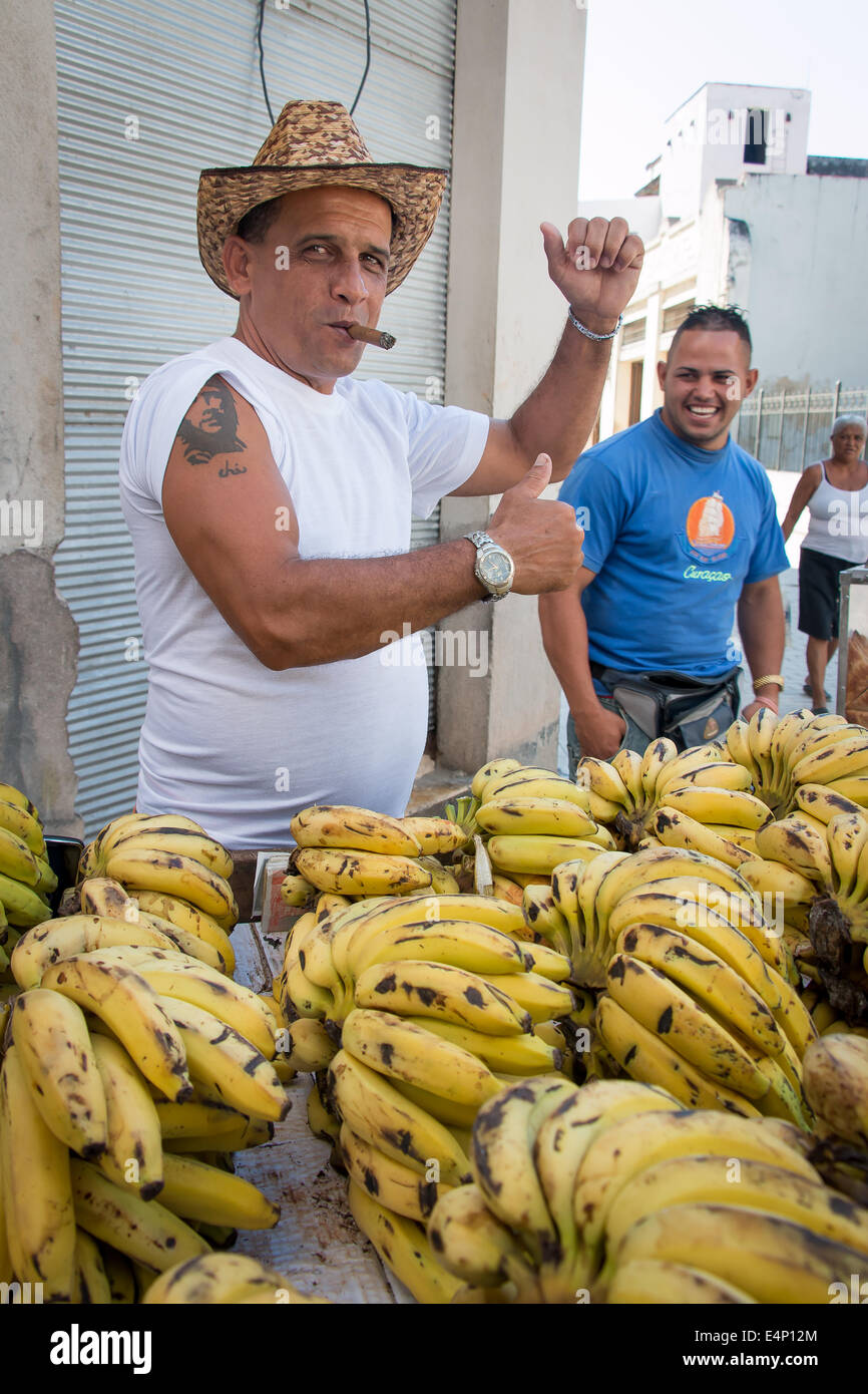 Mann, Verkauf von Bananen und raucht eine Zigarre und zeigt Tattoo von Che Guevara auf seinem Arm, Havanna Vieja (Altstadt von Havanna), Havanna, Kuba Stockfoto